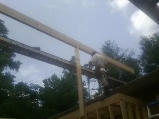 Carpenter setting a ridge beam over a new addition frame — Ice Dam Removal by Roofing Brothers in Bismarck