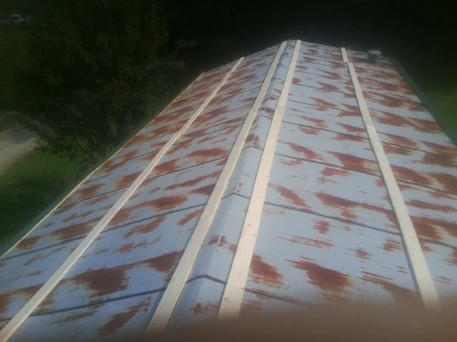 Rusted metal roof panels with new wood purlins before replacement — Storm Damage Roof Repair in Bismarck by Roofing Brothers