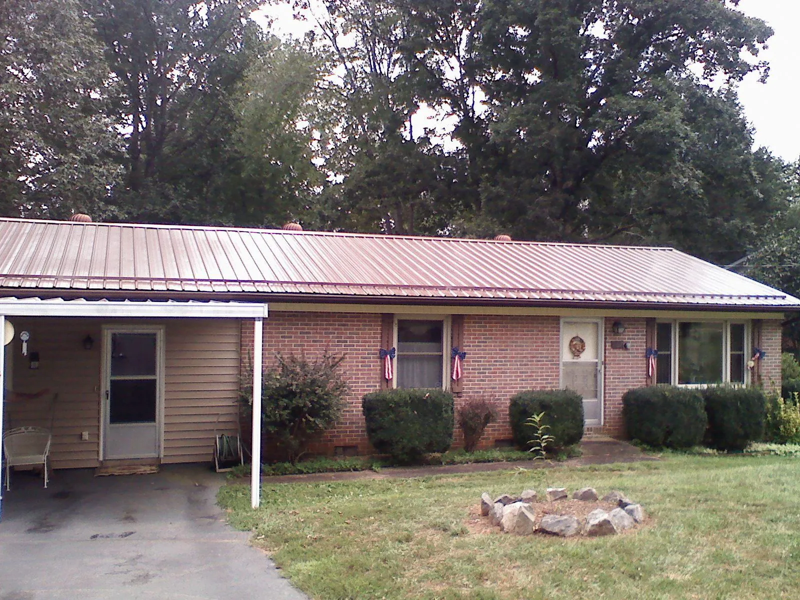 Bronze metal roof and carport on a brick ranch home — Roof Repair work by our crew in Bismarck