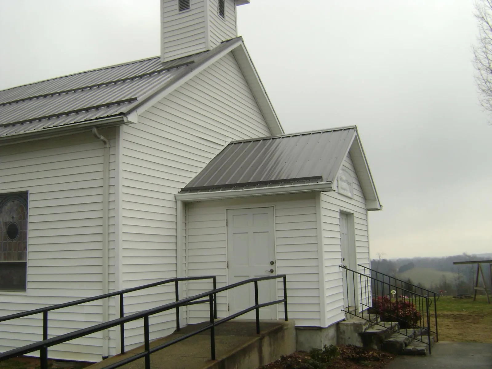 Gray metal roof on a white clapboard church with a steeple in Bismarck