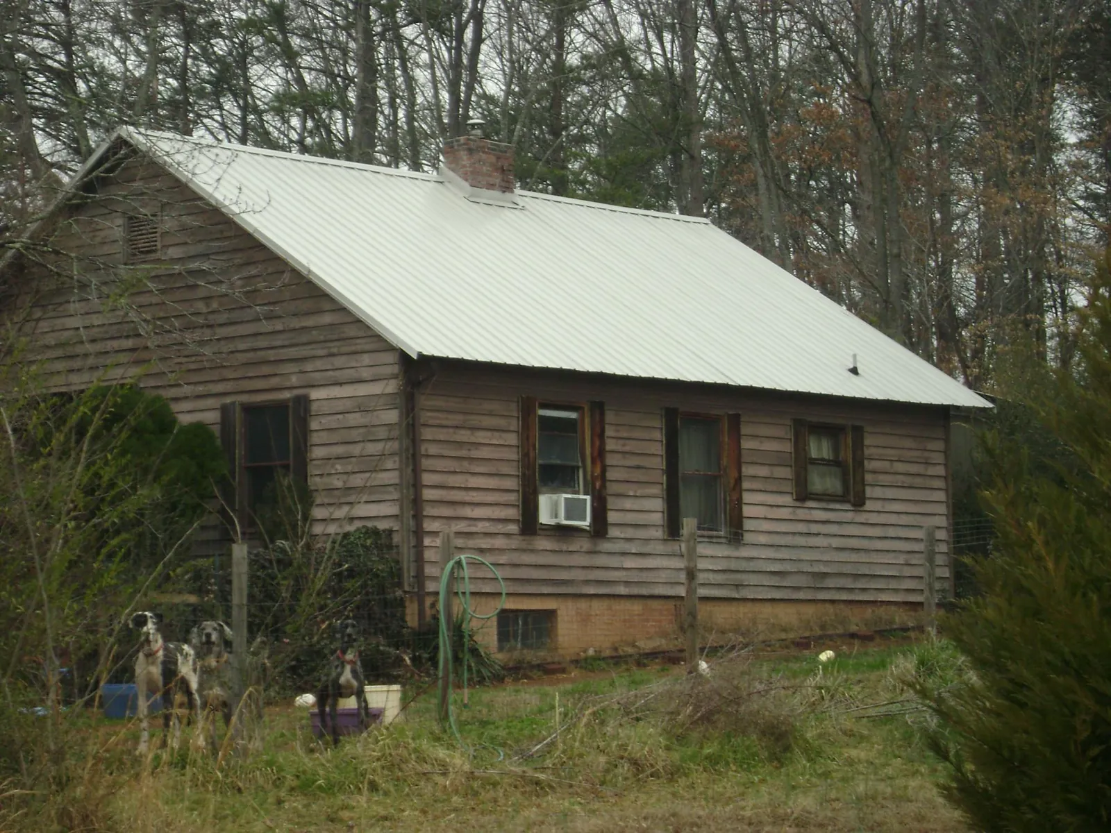 White metal roof on an old wood sided farmhouse, from a Metal Roof Installation job in Bismarck
